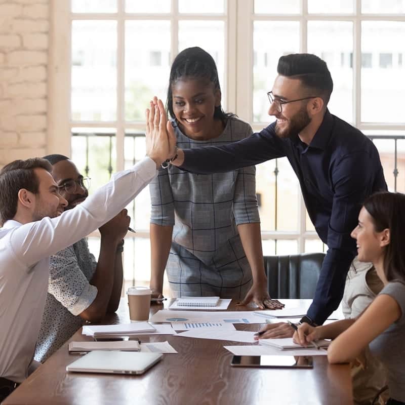 coworkers giving a high five in the office.